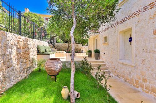 a garden with a tree and a chair and a building at Peninsula Gardens Hotel in Kas