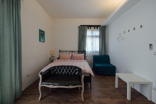 a bedroom with a bed and a blue chair at 5963 Turn Right B&B in Jiaoxi