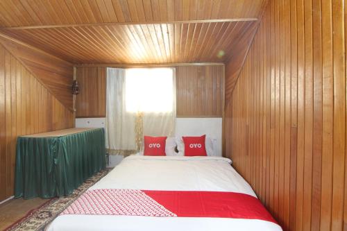 a small bedroom with a bed with red pillows at Penginapan Bunga Sonsang Padang Syariah in Tabing