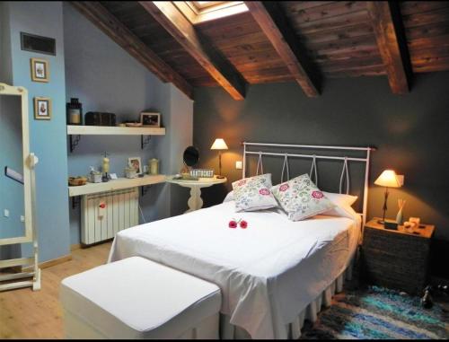 um quarto com uma cama com lençóis brancos e almofadas em Casa Rural " LA PARRA" em Peralejos de las Truchas