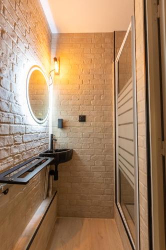 La salle de bains est pourvue d'un lavabo et d'un mur en briques. dans l'établissement Jeanne - Appartement Vue Lac et Montagnes, aux Angles