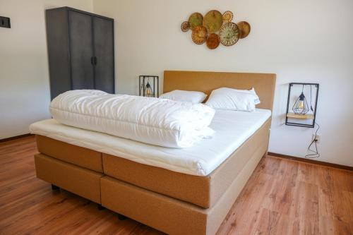 een groot bed met een wit dekbed in een kamer bij Vakantievilla Overberg in Overberg