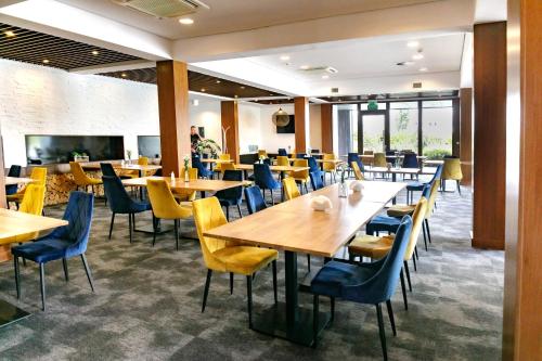 ブジェクにあるHotel Antonio Conferenceの部屋に木製のテーブルと椅子が置かれたレストラン