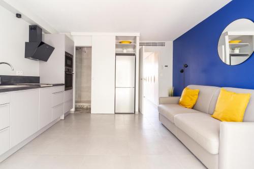 - un salon avec un canapé blanc et un mur bleu dans l'établissement La Bastide de la Plage - Garage privé, à La Ciotat