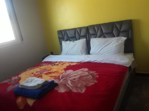 a bedroom with a large bed with a flower blanket at Gîte Forest Tagroumte in Azrou