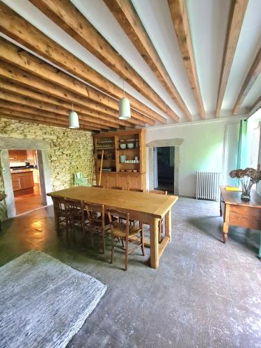 une grande salle à manger avec une table et des chaises en bois dans l'établissement Le Terrier maison de campagne 250 m2 grande capacité 20 couchages, 4500m2 de terrain, à Saint-Pierre-du-Chemin