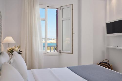 a white room with a bed and a window at Stelia Mare Boutique Hotel in Naousa