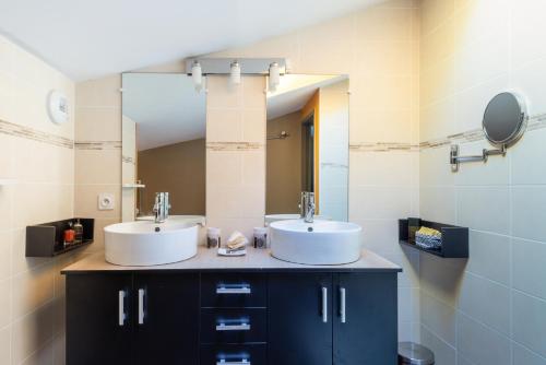 uma casa de banho com 2 lavatórios e um espelho em Le Mas Coste em Aubenas