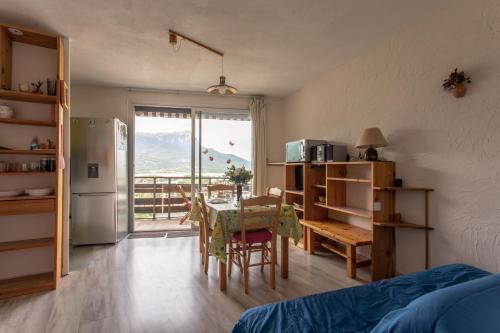 une cuisine avec une table et une salle à manger avec vue dans l'établissement Le Mirador - Studio avec balcon Vue Lac et Montagnes, à Embrun