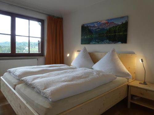 a bedroom with a white bed with a large window at Haus Abendsonne Ferienwohnung Schuster in Krün