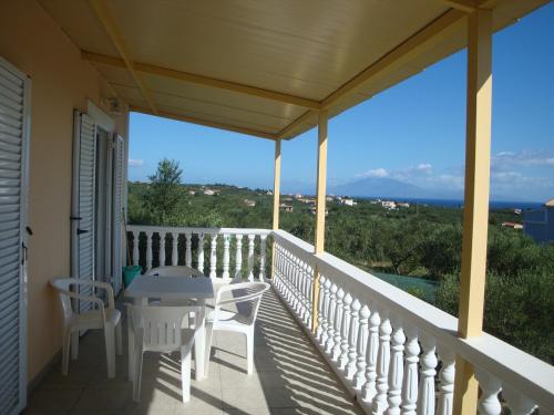 a balcony of a house with a table and chairs at Casa Dyonisia Tsilivi in Plános