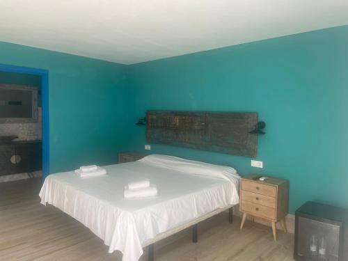 1 dormitorio azul con 1 cama con 2 toallas en Habitaciones Sajorami Beach en Zahora