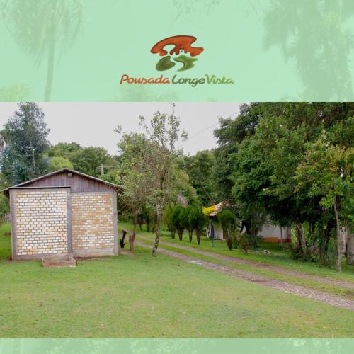 a small building in a grassy area next to a field at Pousada Longe Vista in Tibagi