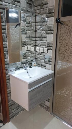 a bathroom with a sink and a stone wall at Maison GHITA in Azrou