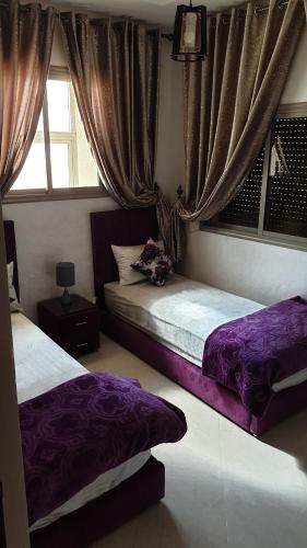 Un dormitorio con dos camas y una ventana. en Maison GHITA, en Azrou