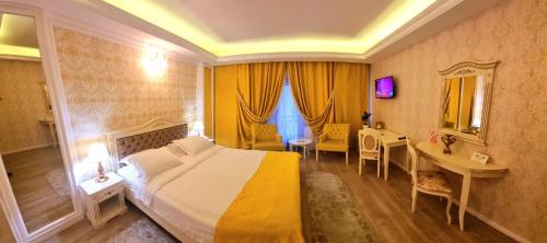 a hotel room with a large bed and a desk at Grand Hotel Baroc in Zalău