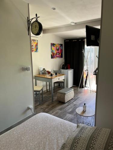 a bedroom with a desk and a table with a clock at La Cuisine d'été de BeaunAmour in Beaune