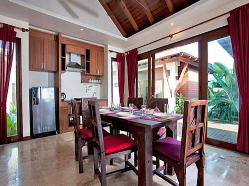 a kitchen and dining room with a wooden table and chairs at Thai Island Dream Estate in Ko Lanta
