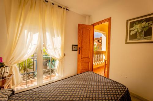 a bedroom with a bed and a large window at Hotel Cafe La Morena in Fuengirola