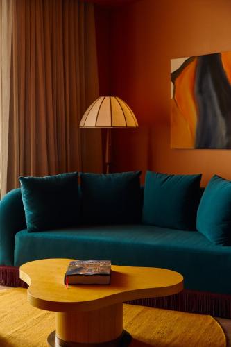 a living room with a blue couch and a table at Mayfair House Hotel & Garden in Miami