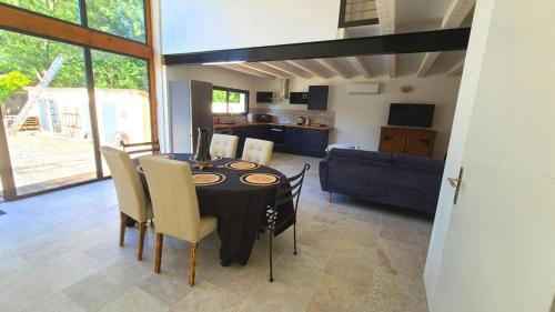 une salle à manger avec une table et des chaises et une cuisine dans l'établissement La grange ô bien être, à Bercloux