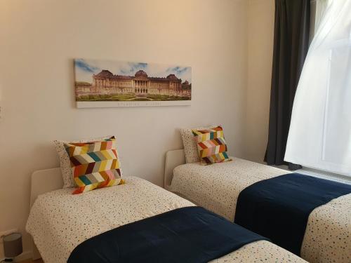 1 dormitorio con 2 camas y una foto en la pared en Chez Esmara et Philippe Grand-Place en Bruselas