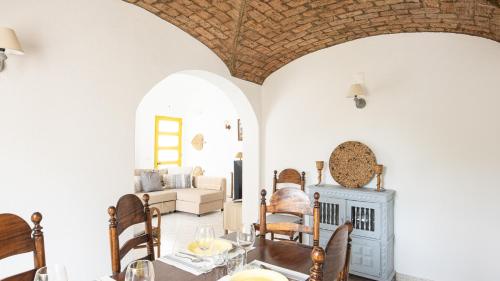 a living room with a table and chairs and a fireplace at Villa Aldeia do Golf - BY BEDZY in Vilamoura