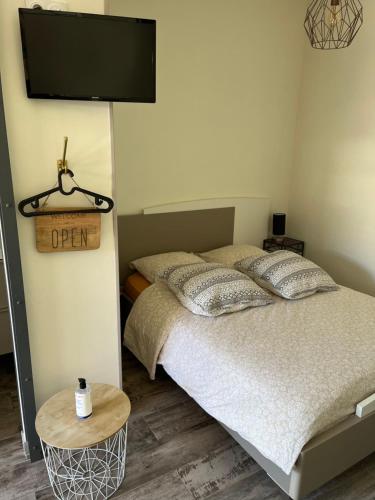 a bedroom with a bed and a flat screen tv at La Cuisine d'été de BeaunAmour in Beaune