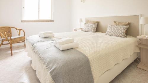 1 dormitorio con 1 cama grande y toallas. en Villa Aldeia do Golf - BY BEDZY, en Vilamoura