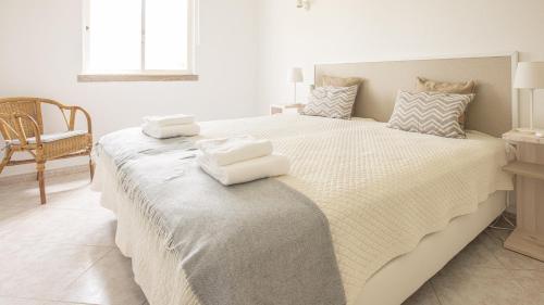 a bedroom with a large bed with towels on it at Villa Aldeia do Golf - BY BEDZY in Vilamoura