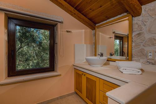 a bathroom with a sink and a window at Kymaros Villas in Keri