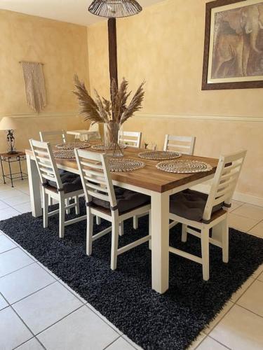 une table à manger avec des chaises blanches et une table dans l'établissement Nid Zen & Spa La Touche, à Vierzon