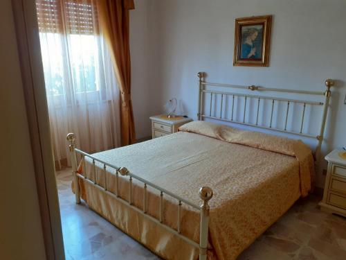 Schlafzimmer mit einem Bett und einem Fenster in der Unterkunft B&B ANNA in Piscinas