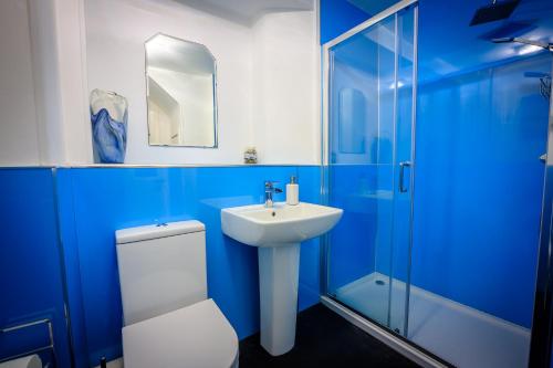 a blue bathroom with a toilet and a sink at Cosy Cottage in Fishertown, Nairn - Free Parking & Pets welcome in Nairn