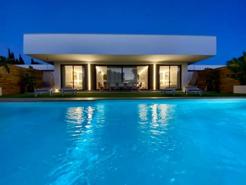 a villa with a swimming pool at night at VISTA LAGO VILLE in Chiclana de la Frontera