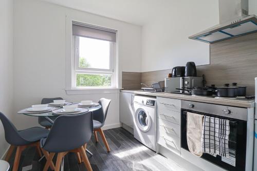 a kitchen with a table and a stove top oven at The Cove Apartment in Gourock