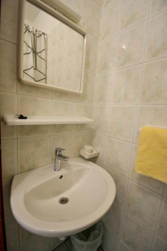 a bathroom with a white sink and a mirror at Holiday Home Olivetree Rab in Supetarska Draga