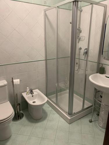 een badkamer met een douche, een toilet en een wastafel bij I Platani 3 in Montecatini Terme