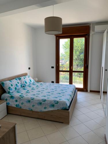 a bedroom with a bed and a large window at I Platani 3 in Montecatini Terme