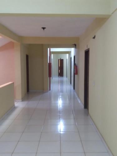 un corridoio vuoto di un edificio con pavimenti piastrellati bianchi di HOTEL RIO TAPAJOS a Santarém
