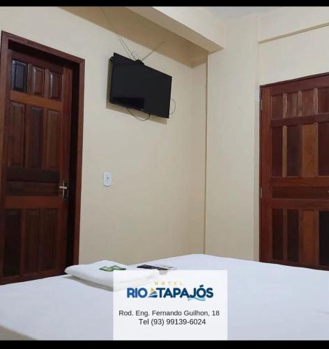 Zimmer mit 2 Türen und einem TV an der Wand in der Unterkunft HOTEL RIO TAPAJOS in Santarém