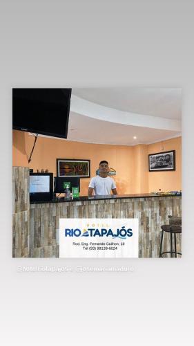 Un uomo in piedi dietro un bar in un ristorante di HOTEL RIO TAPAJOS a Santarém