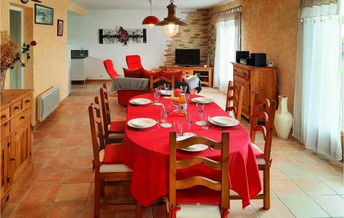 une salle à manger avec une table et des chaises rouges dans l'établissement 3 Bedroom Awesome Home In Plourivo, à Plourivo
