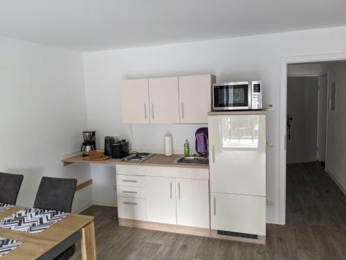 a kitchen with a white refrigerator and a microwave at Gut schlafen in der Innenstadt von Zittau - Ferienwohnungen IO19 in Zittau