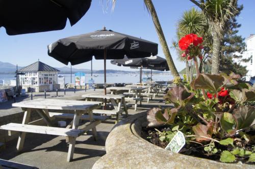 a patio area with tables, chairs and umbrellas at The Bulkeley Hotel in Beaumaris