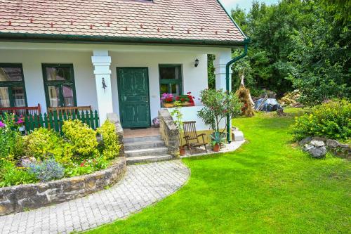 a house with a green door and a garden at Falubíró Vendégháza in Bekölce