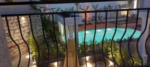 a view of a swimming pool through a fence at Hotel Doğa Çeşme in Çeşme