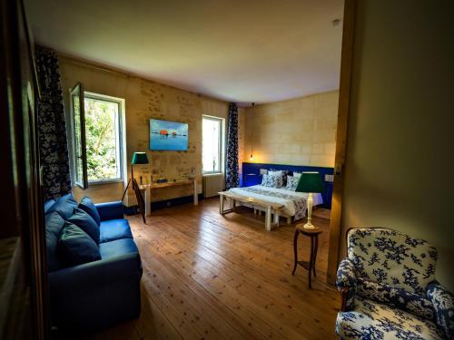 un salon avec un canapé et un lit dans l'établissement Petit Garros, à Fronsac