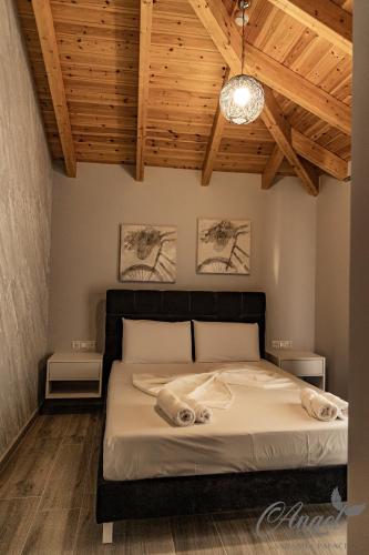a bedroom with a bed in a room with wooden ceilings at Angel Saranda Palace in Sarandë