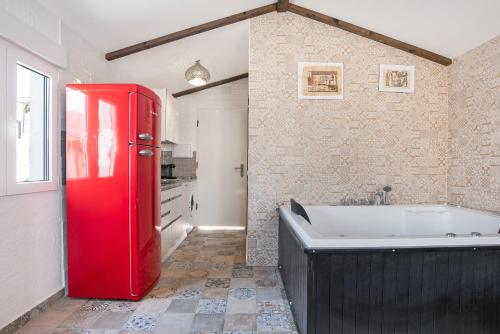a bathroom with a red refrigerator and a bath tub at Villa Egipto in Chiclana de la Frontera